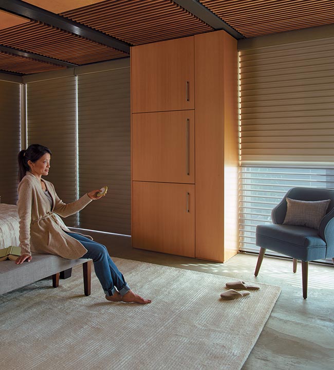 person controlling automatic window shades in bedroom in Nova Scotia home