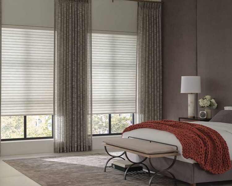 bedroom with patterned side panel drapery and white cellular window shades