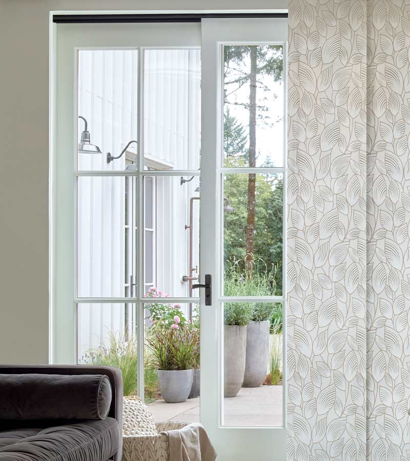 botanical patterned window panels on glass doors leading to back yard