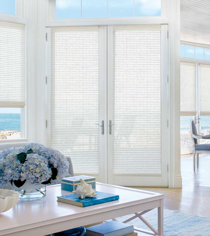 white woven window shades on glass doors to patio