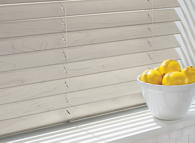 gray faux wood window blinds in kitchen with bowl of lemons
