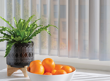 kitchen with sheer vertical shades with bowl of oranges