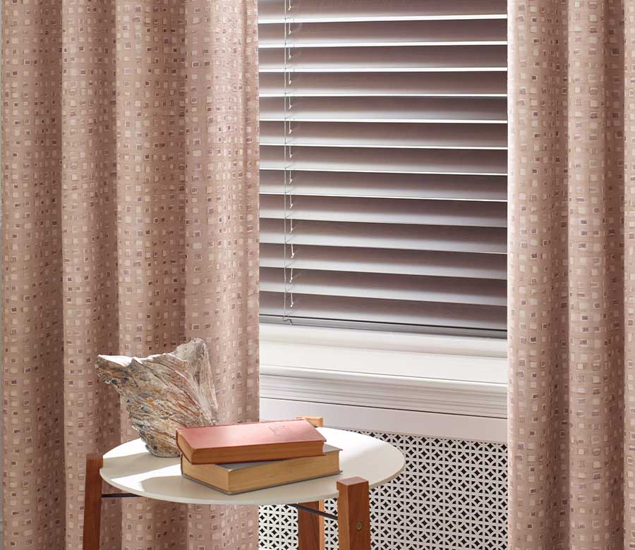 pink custom drapery in bedroom paired with window blinds