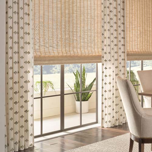 provenance-woven-wood-shades-layered-with-custom-drapery-hunter-douglas-seeview-blinds patterned drapery in living room along with natural woven wood shades layered for a bohemian modern look
