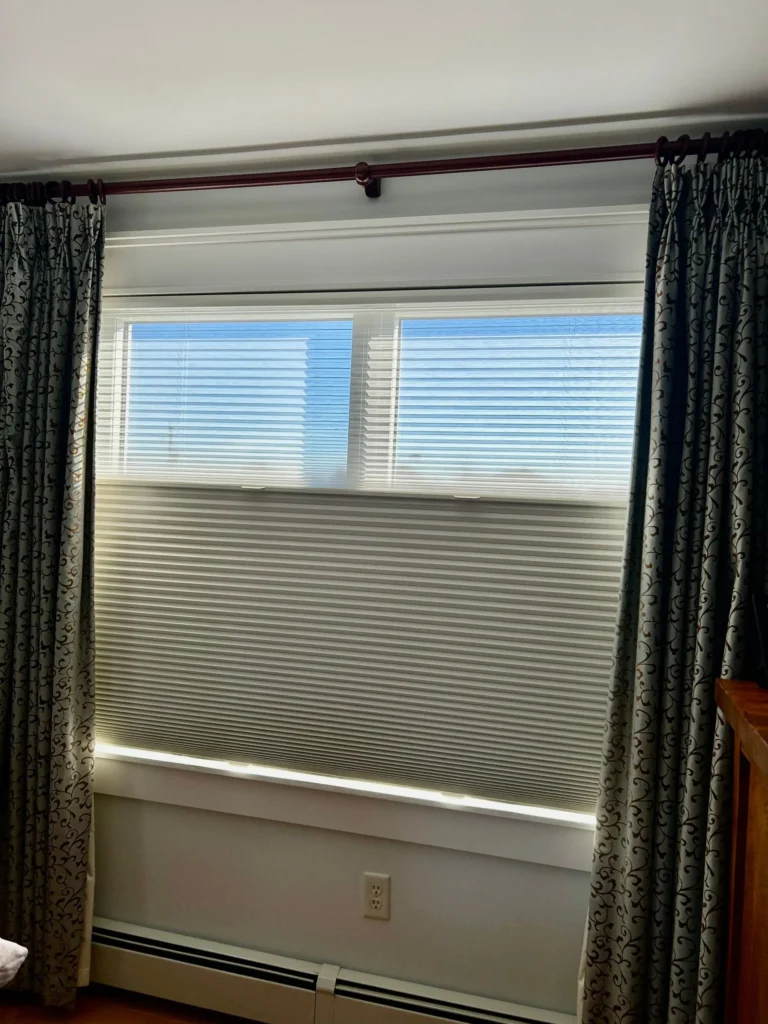 bedroom with drapery and cellular window shades in bedroom