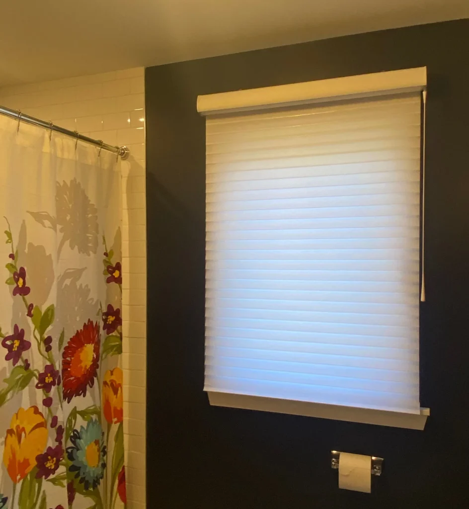 white window covering shades in bedroom
