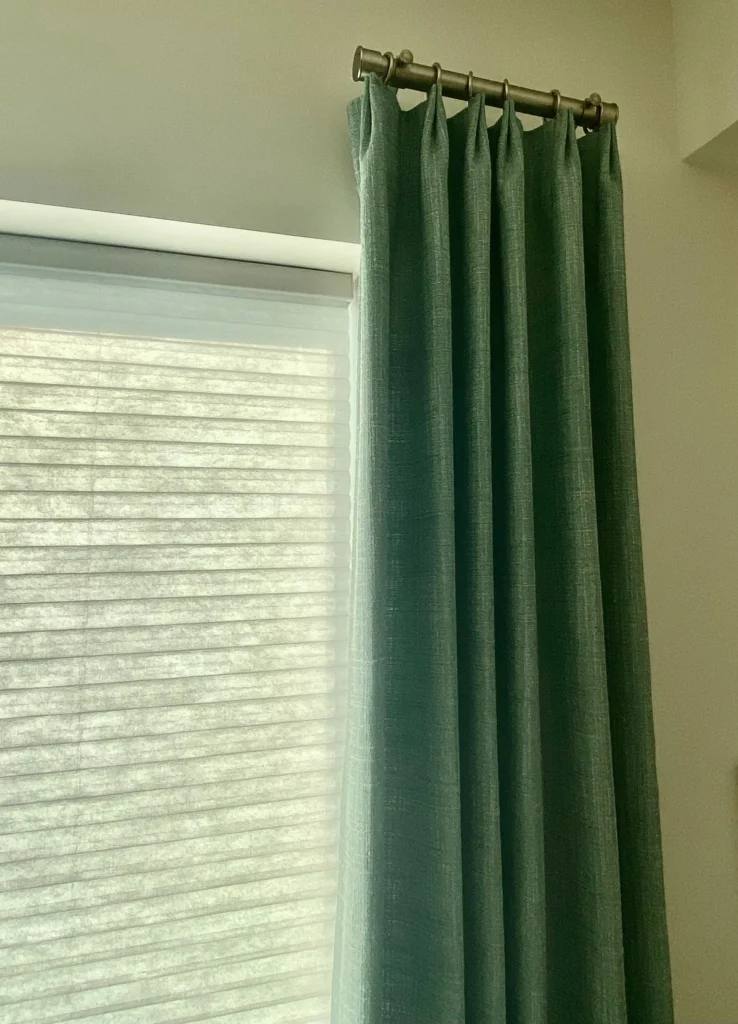 drapery paired with window honeycomb blinds in bedroom