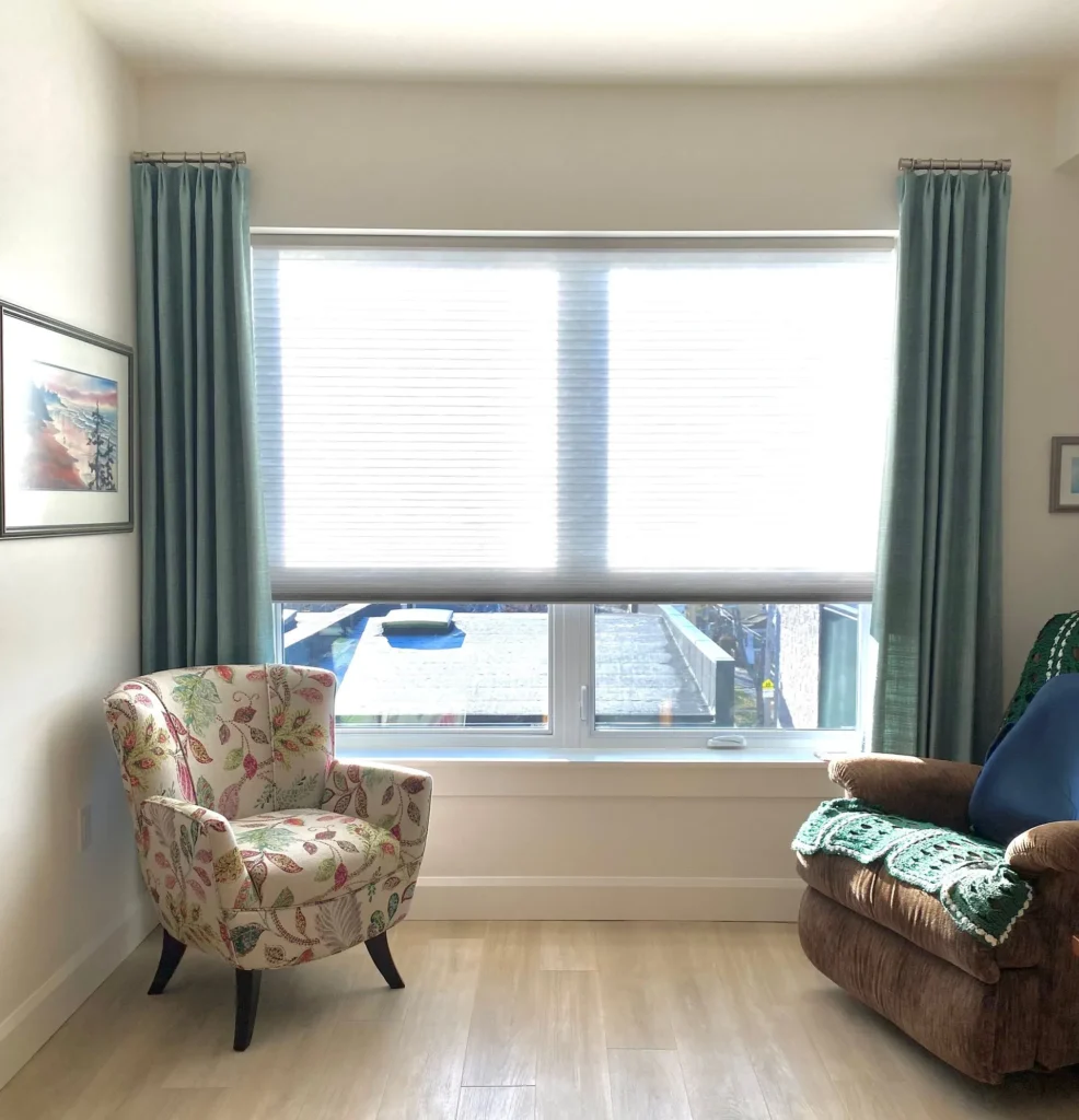 drapery paired with honeycomb window shades in bedroom