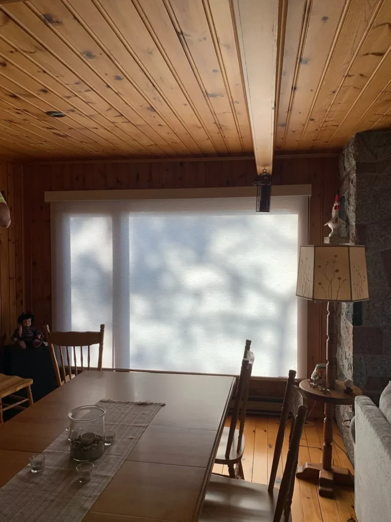 white screen shades in dining room with wood ceiling