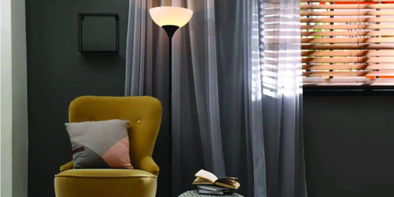 pairing drapery with window coverings in bedroom with yellow chair