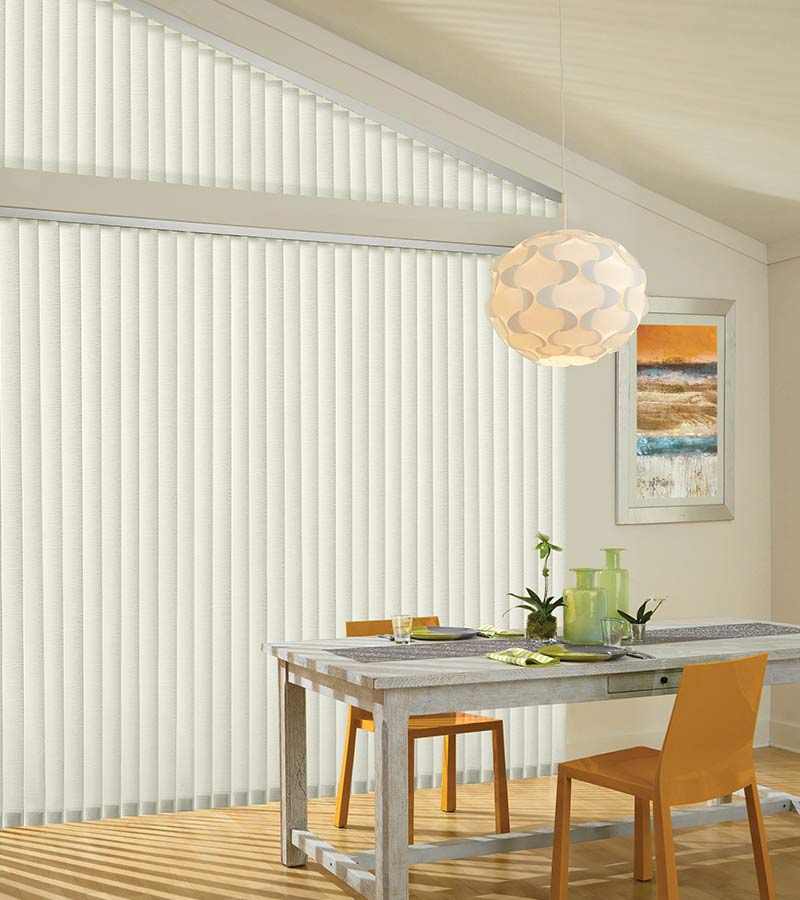 vertical window blinds in dining room with angled windows