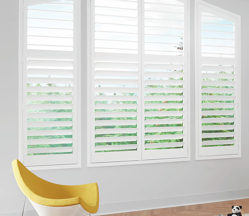 large white window shutters in child bedroom with yellow chair