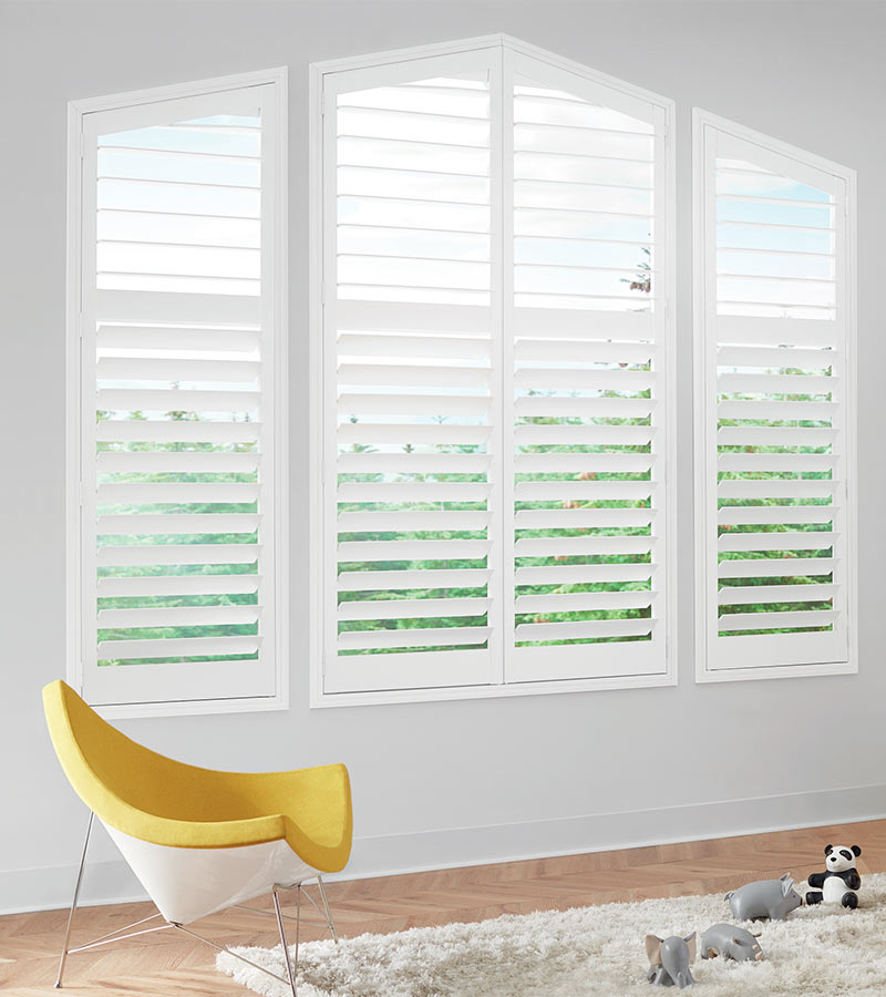 large white window shutters in child bedroom with yellow chair