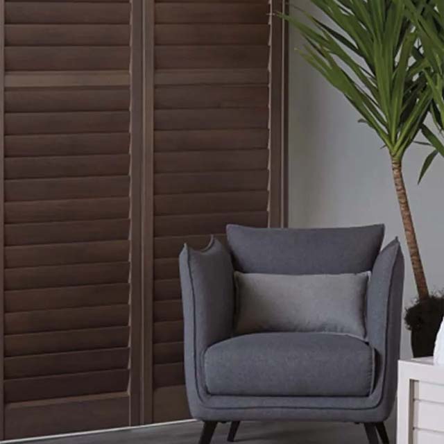 ultimate-comfort dark brown wood shutters on glass doors in living room