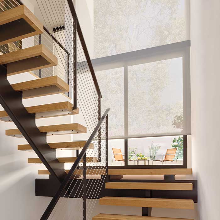 Designer Solar Shades in switchback staircase on floor to ceiling windows for reduced glare and UV protection